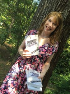 Jenny outdoors holding a copy of her book