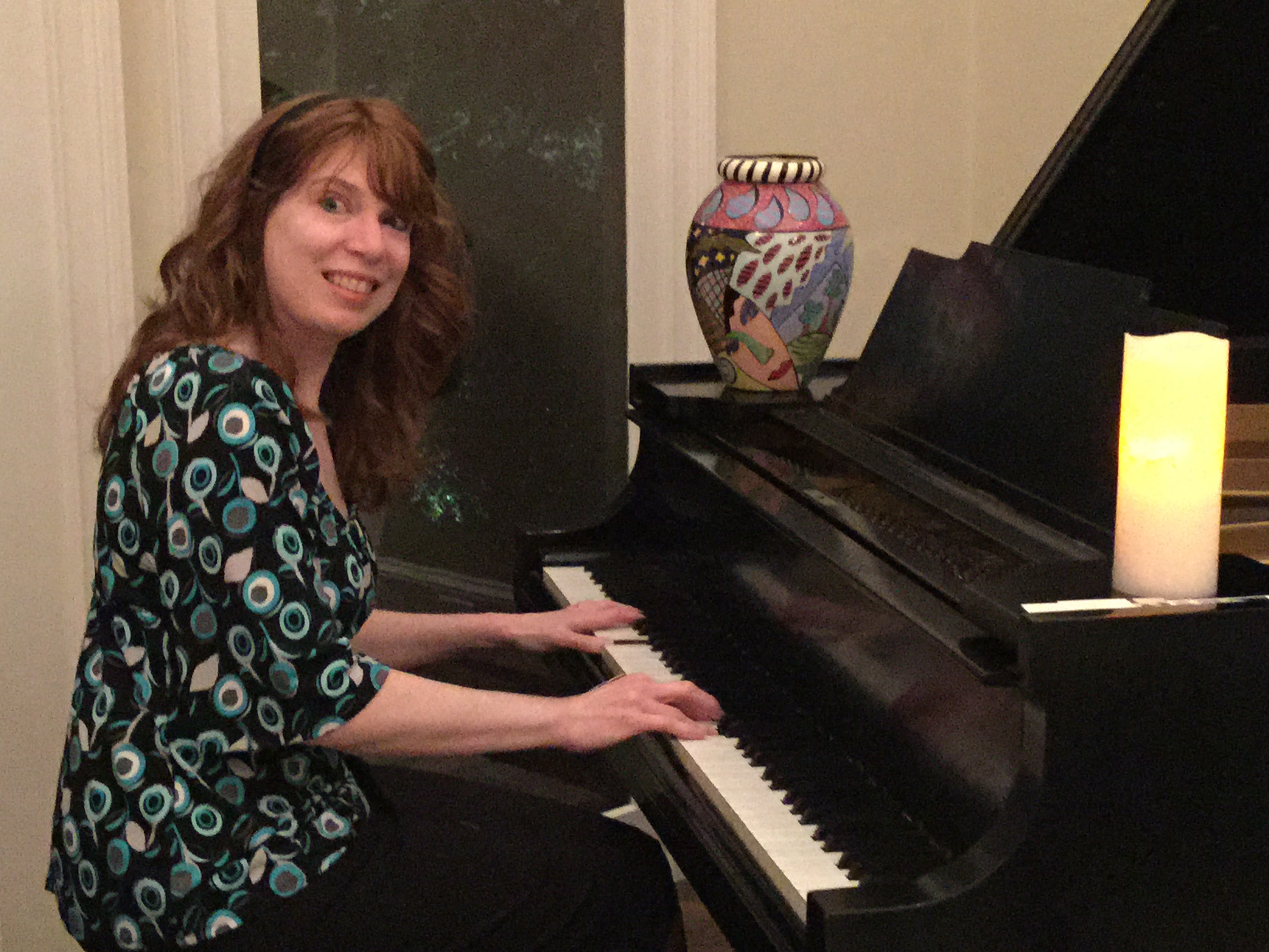 Jenny playing a grand piano at a Christmas party