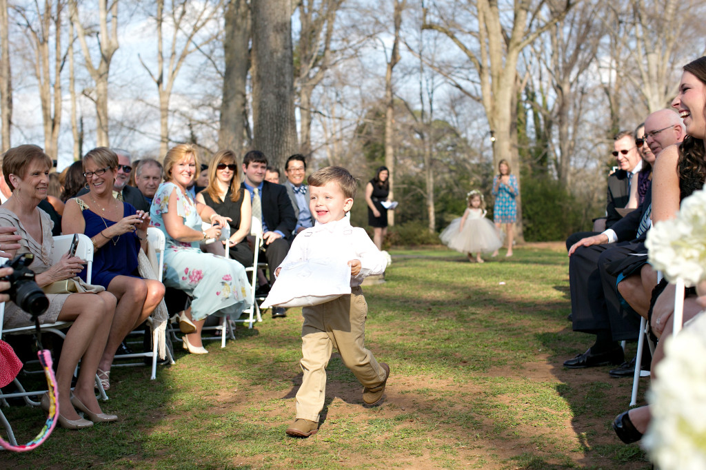 Ring bearer happily running down the aisle at outdoor Atlanta wedding callanwolde gardens fine arts center