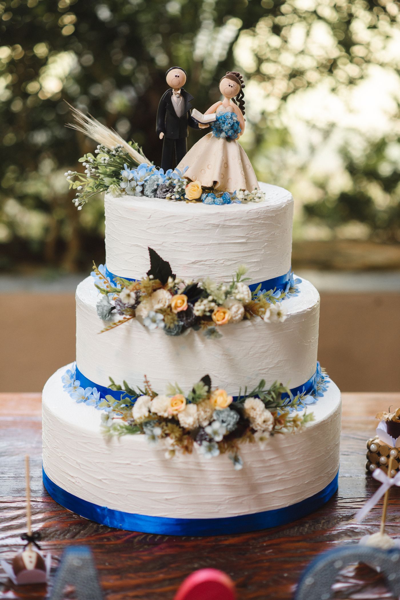 Bride and groom figurines on a flower-decorated wedding cake