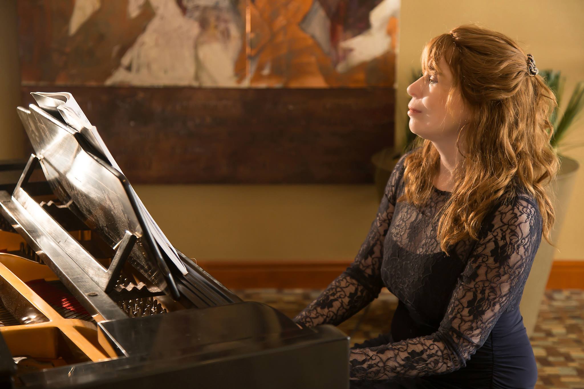 Jenny playing the piano in a black lace dress at the Westin Buckhead