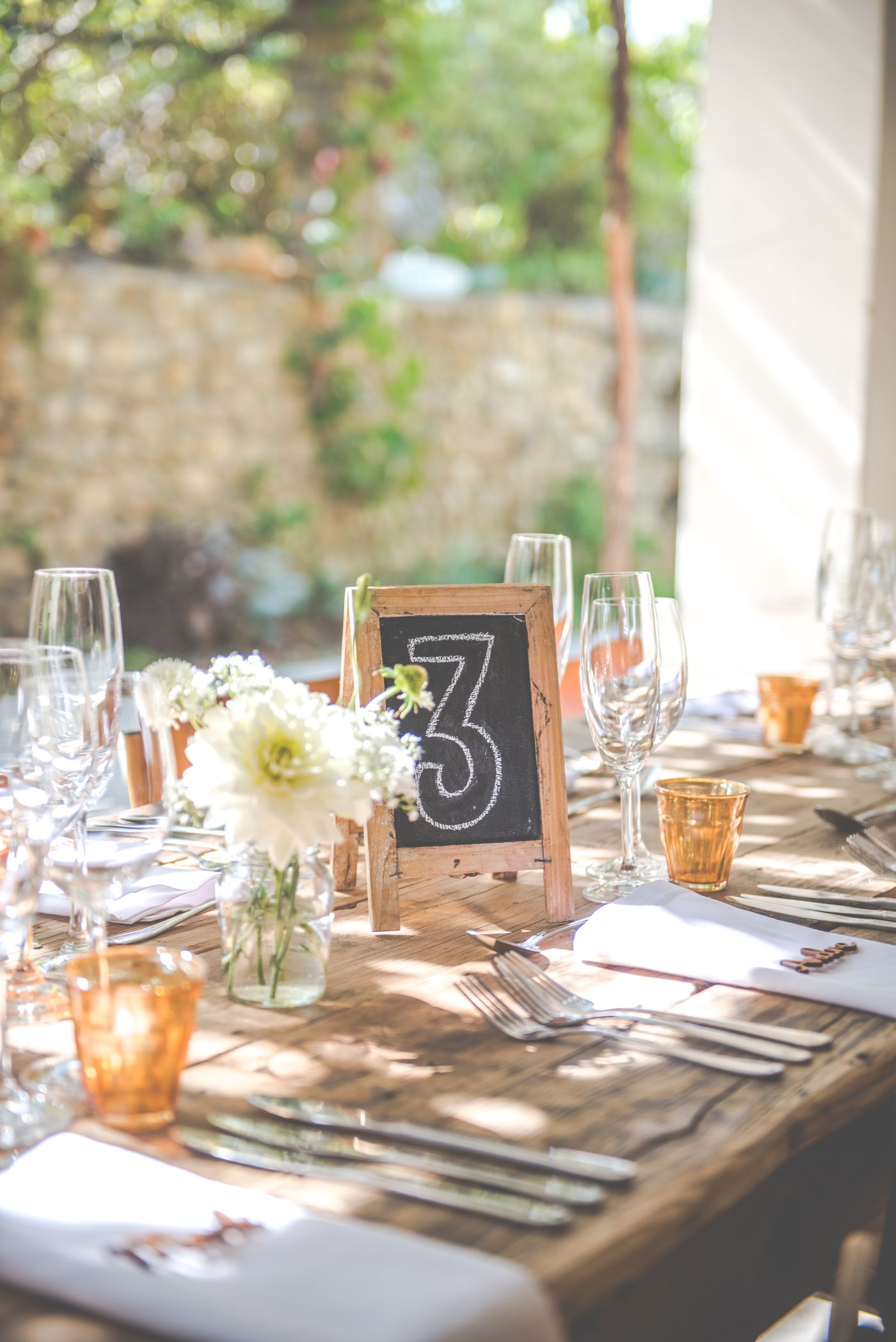 A rustic reception table set with flowers and tableware