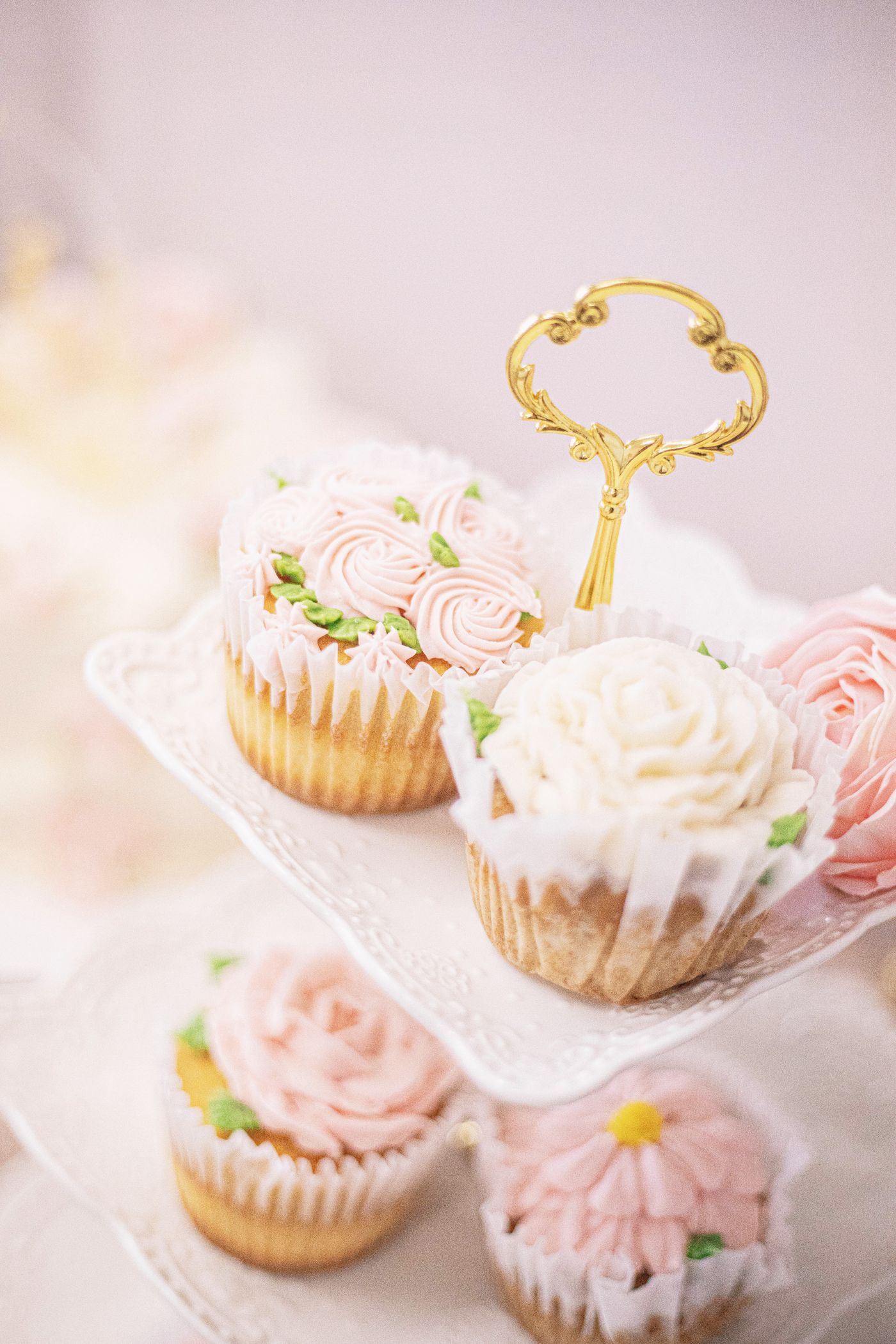 Delicate pink cupcakes displayed on a tiered stand