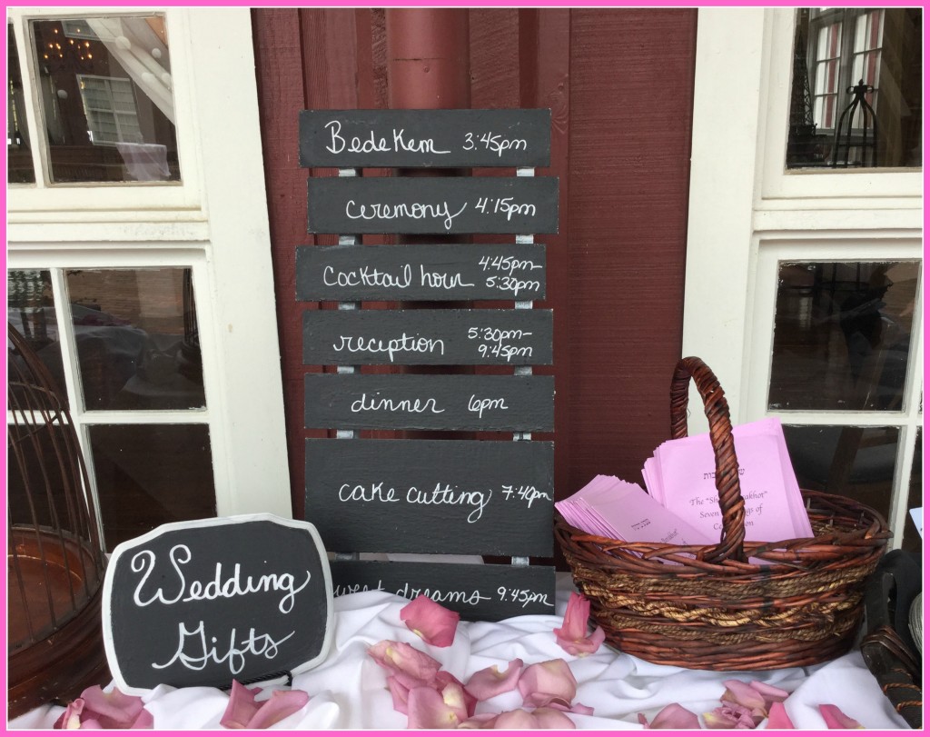 The welcome table and wedding-day schedule at an outdoor celebration