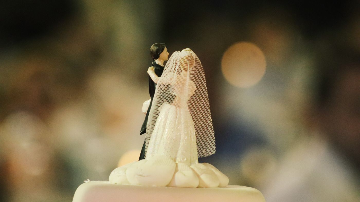 A bride and groom figurine wedding cake topper