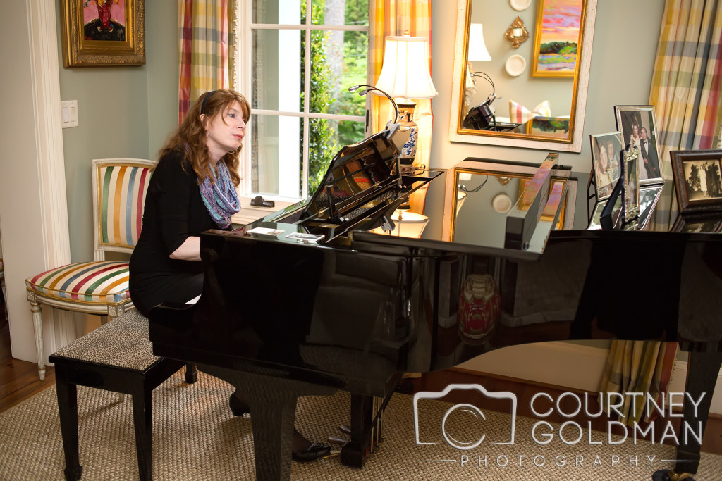 Jenny playing a grand piano beside a sunlit window