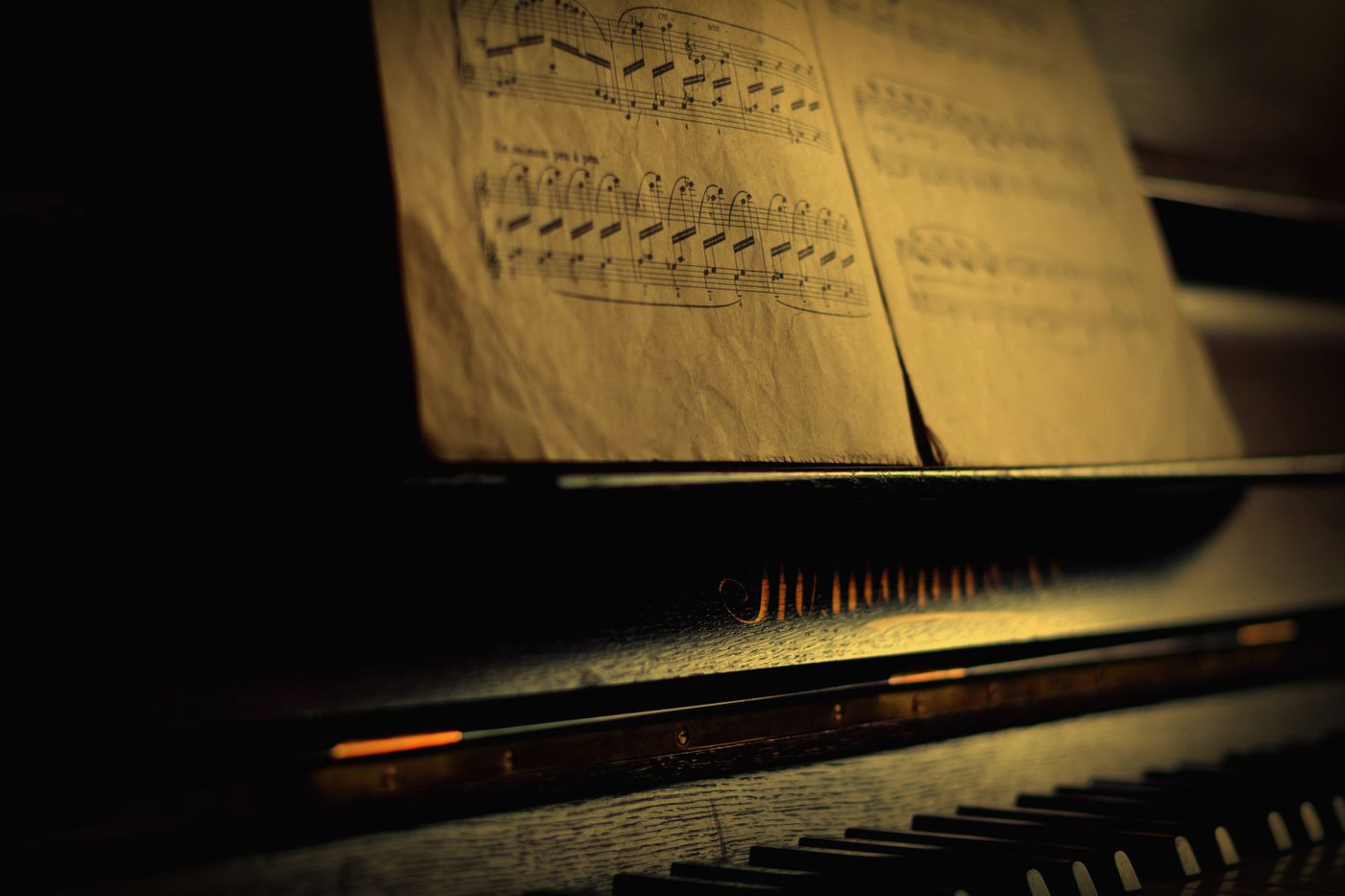 Sheet music and piano keys in warm light
