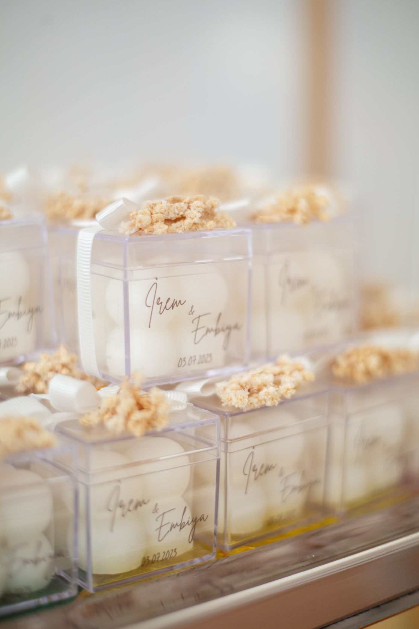 Wedding favor boxes with white ribbons and personalized labels