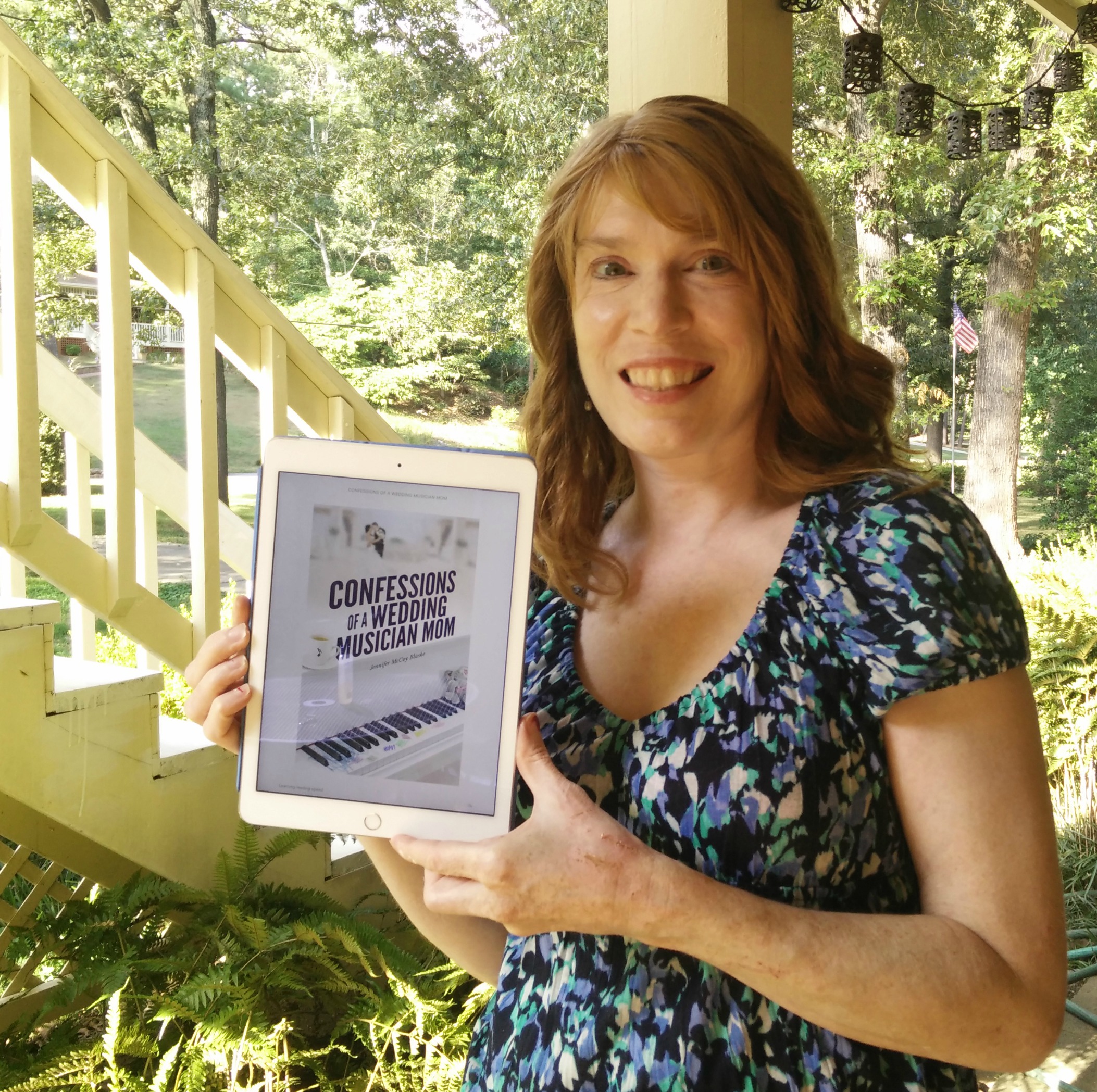 Jenny holding her book, Confessions of a Wedding Musician Mom