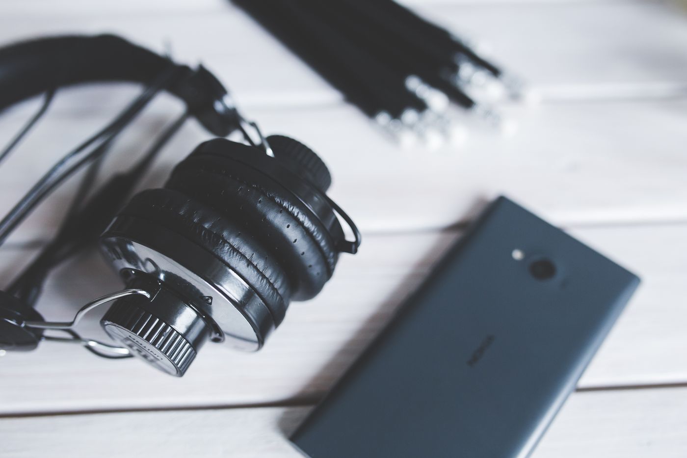 Headphones and a smartphone resting on a wooden table