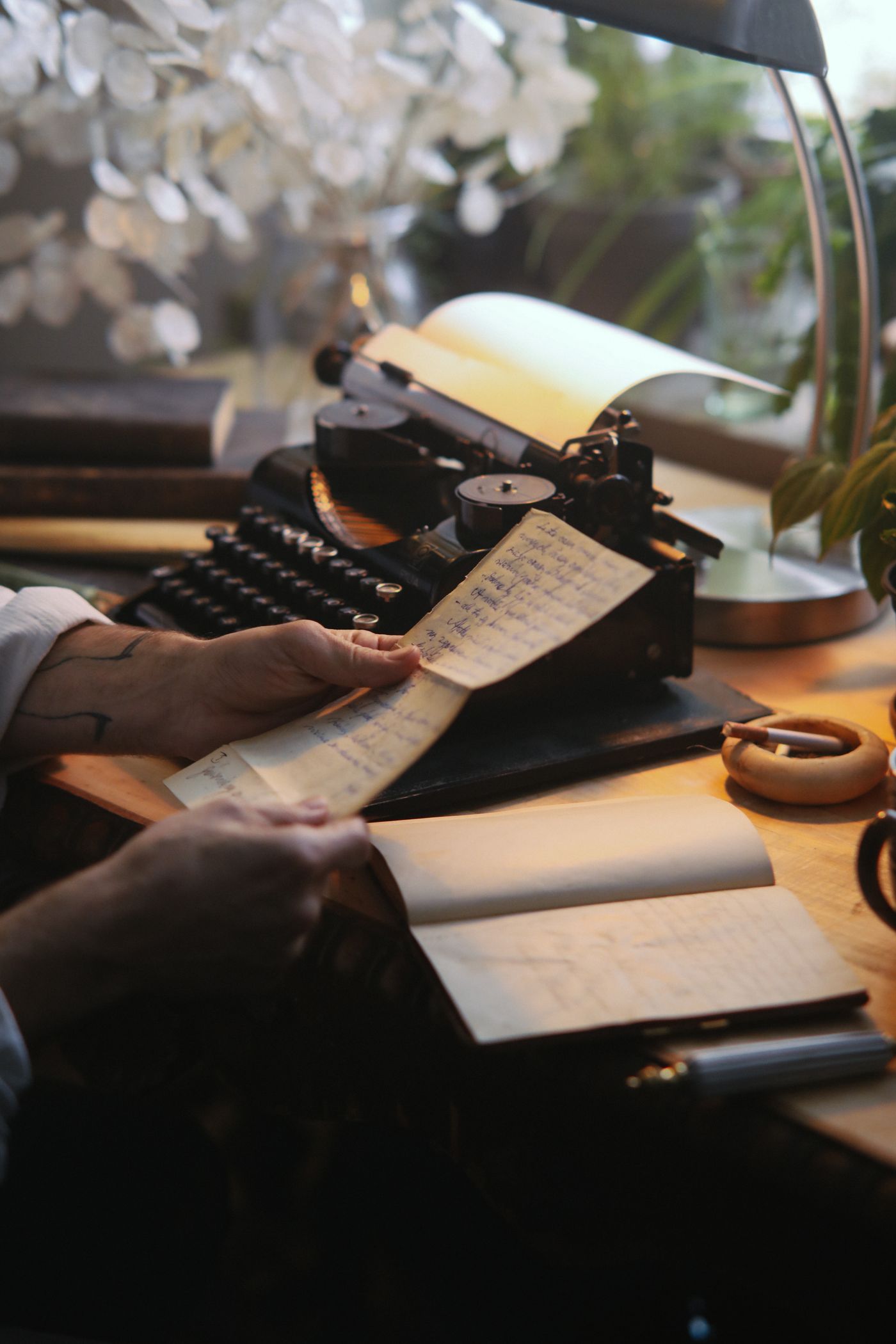 A handwritten page beside a vintage typewriter