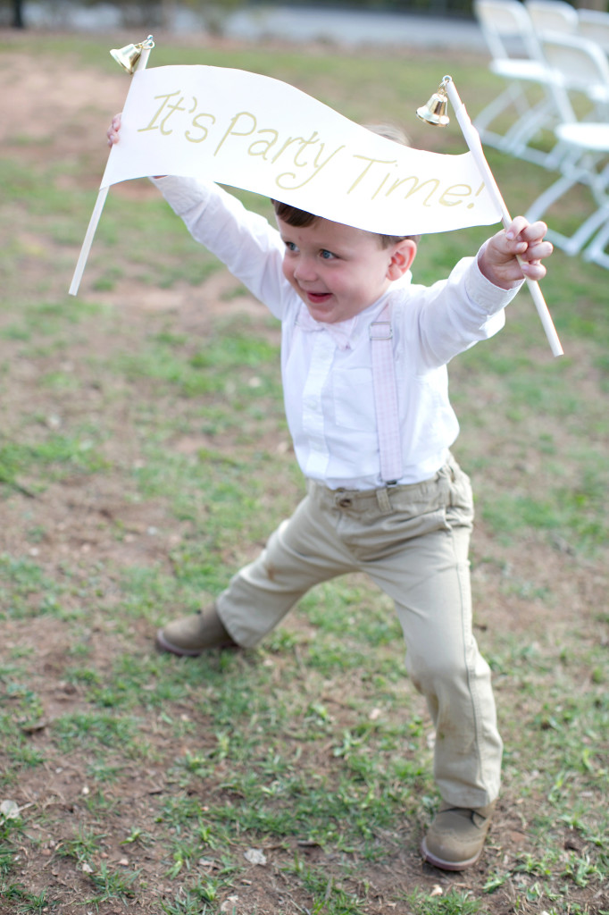 Ring bearer holding Its party time sign before wedding reception at Callanwolde fine arts center in Atlanta