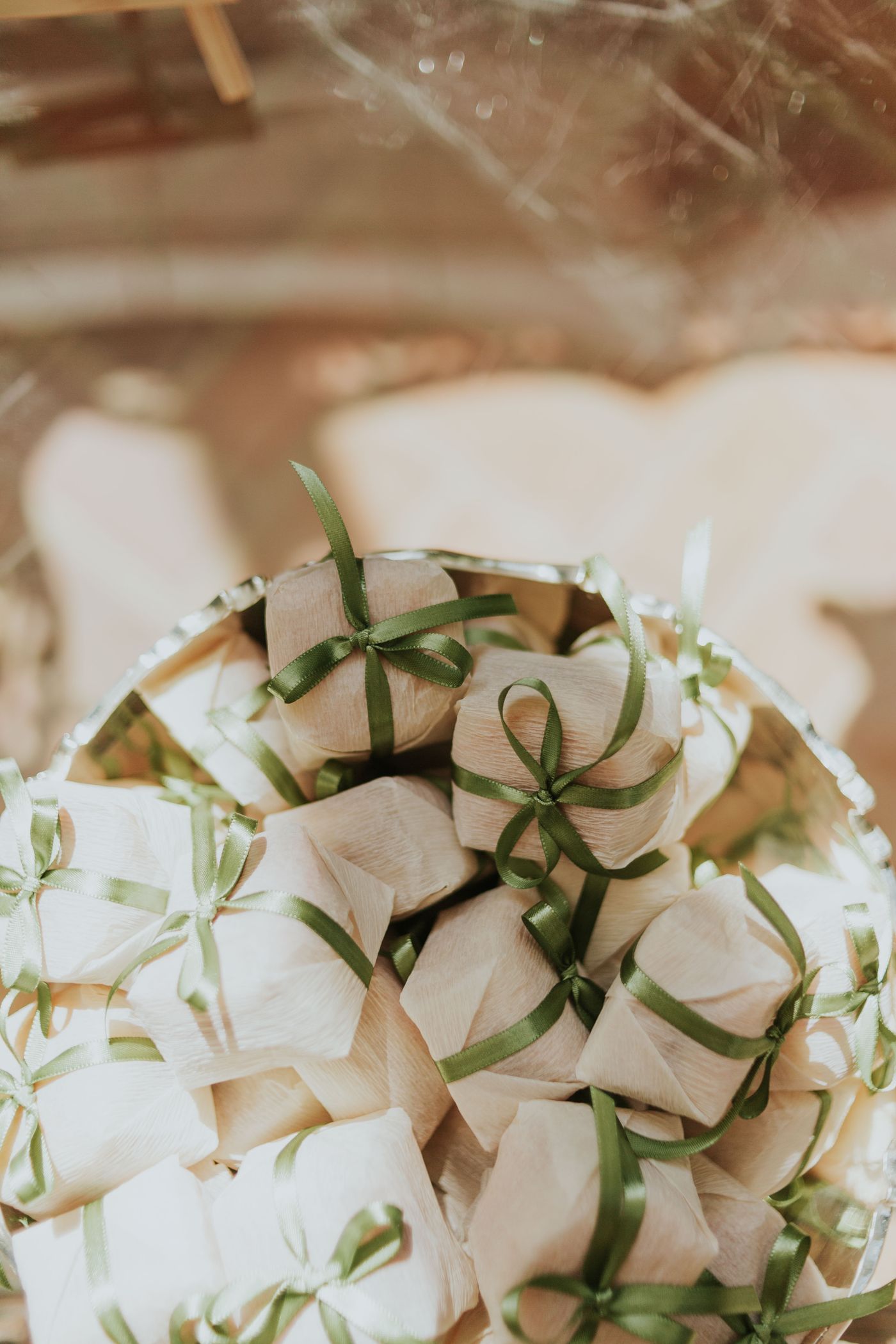 Wedding favor boxes tied with soft green ribbons