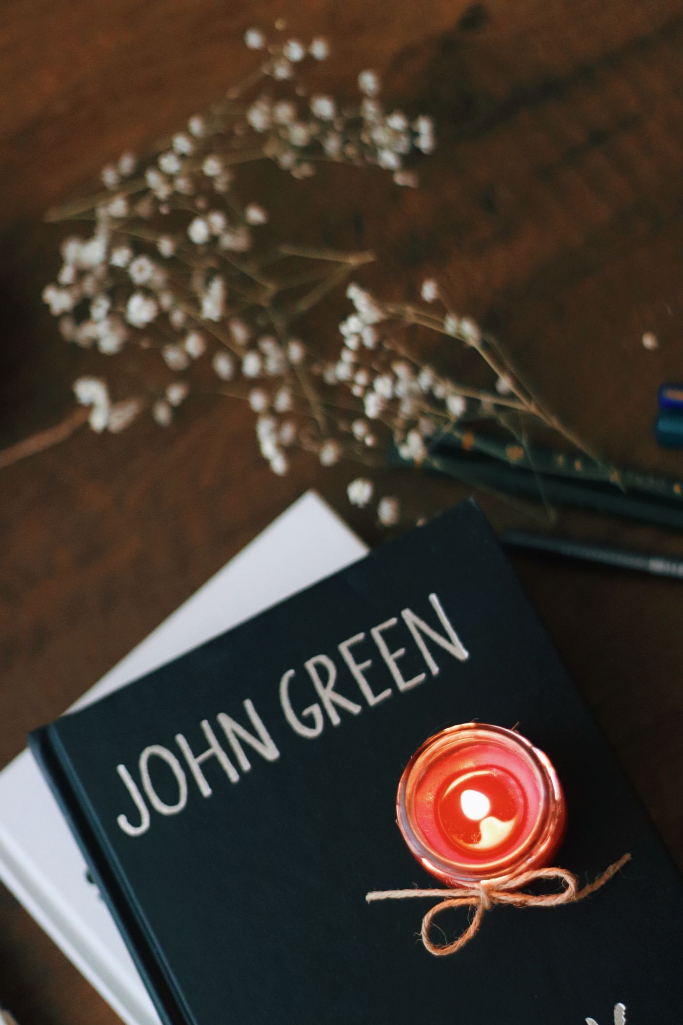 Books, a candle and dried flowers on a wooden table