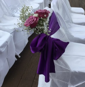 Pink flowers with purple ribbon and bow at outdoor wedding at Ivy Hall in GA